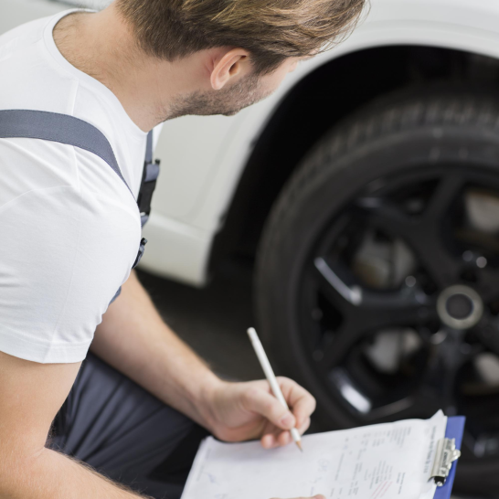Mężczyzna spoglądający na koło samochodu