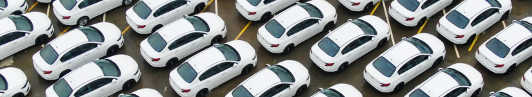 Parking z dużą liczbą białych samochodów osobowych